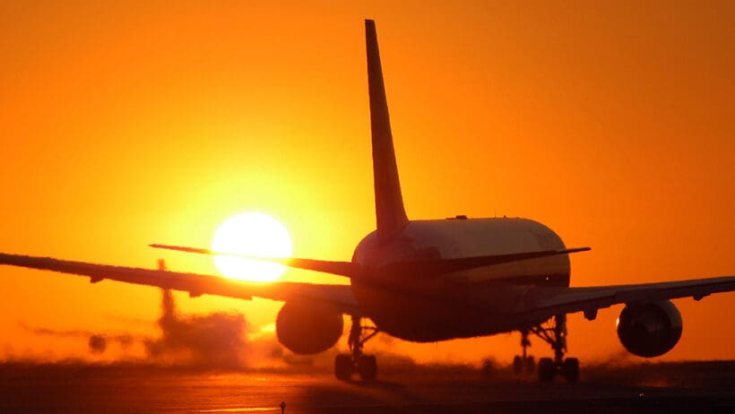 an airplane on the runway at sunset