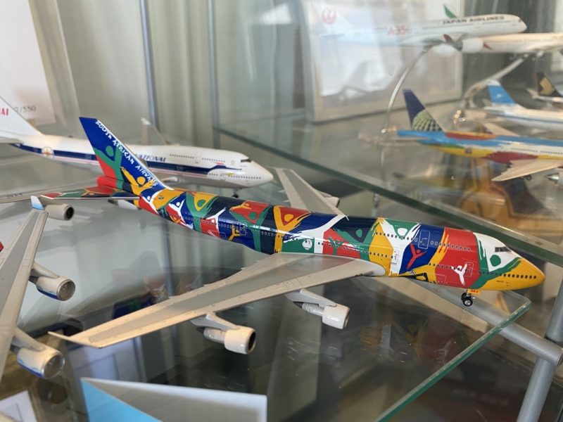 a group of model airplanes on a glass shelf