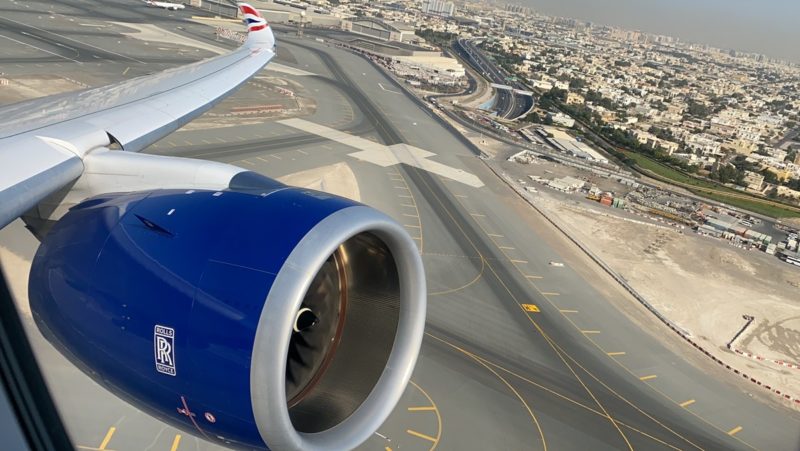 an airplane wing and engine above a runway