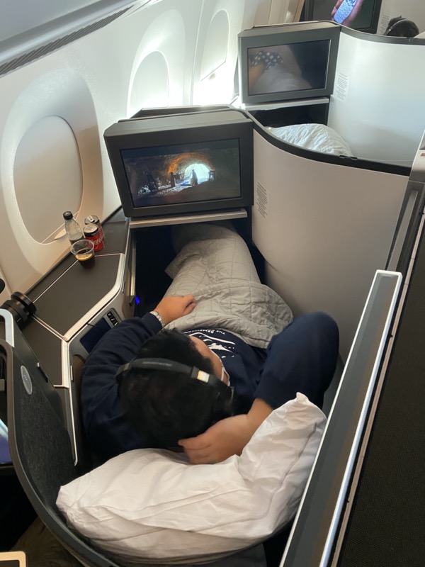 a person lying in a bed with headphones on