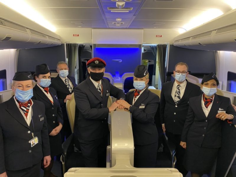 a group of people wearing masks and standing in a plane