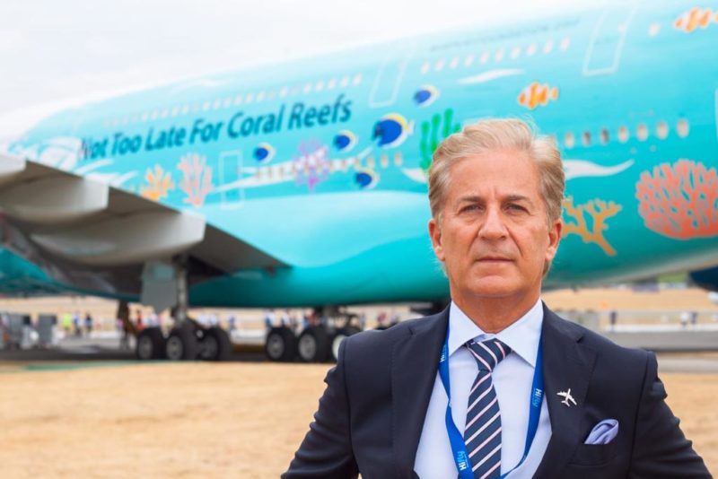 a man in a suit standing in front of an airplane