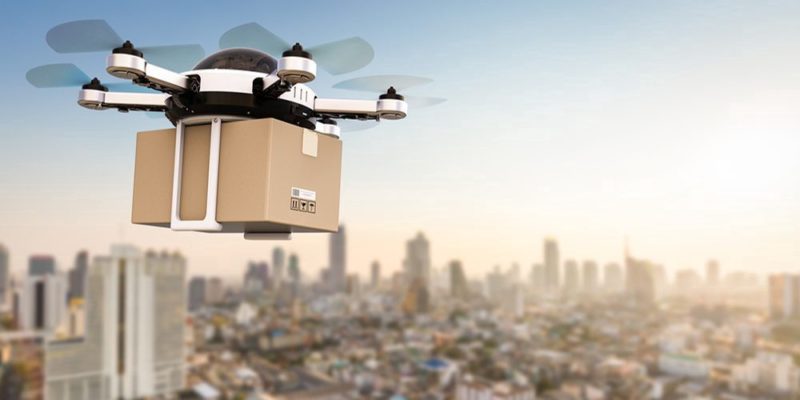 a drone flying with a box in the air