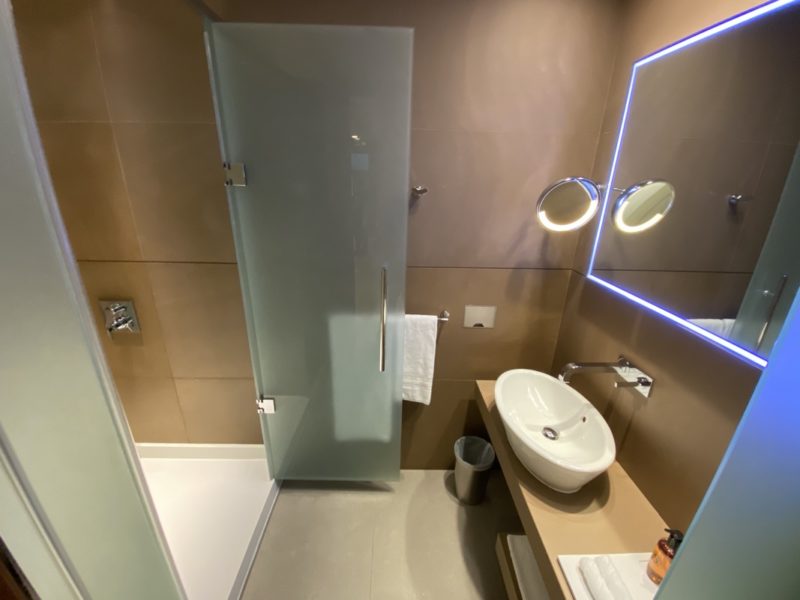 a bathroom with a glass door and a mirror