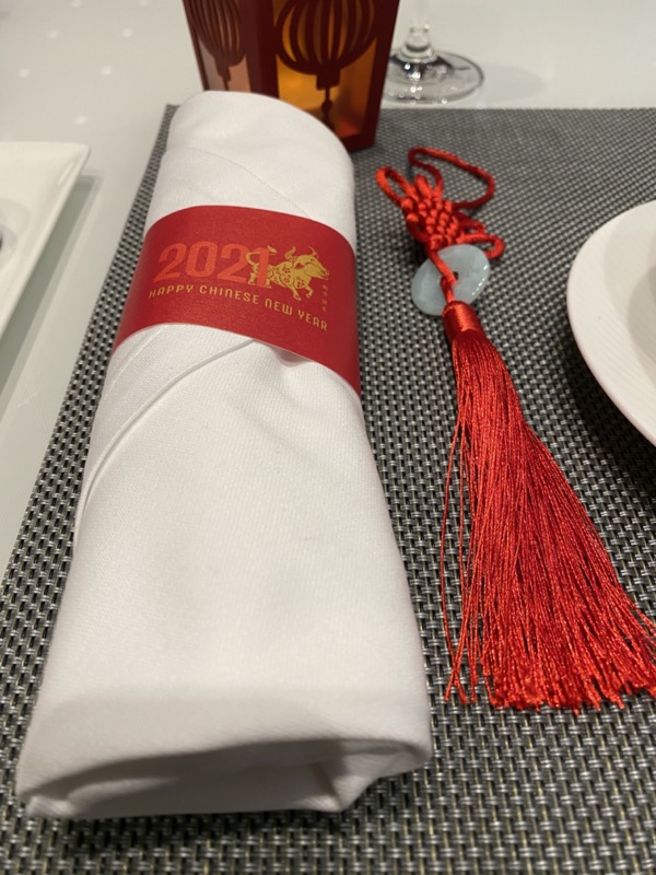 a napkin with a red ribbon and a tassel