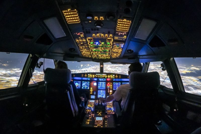 a cockpit of a plane with lights and people in the cockpit