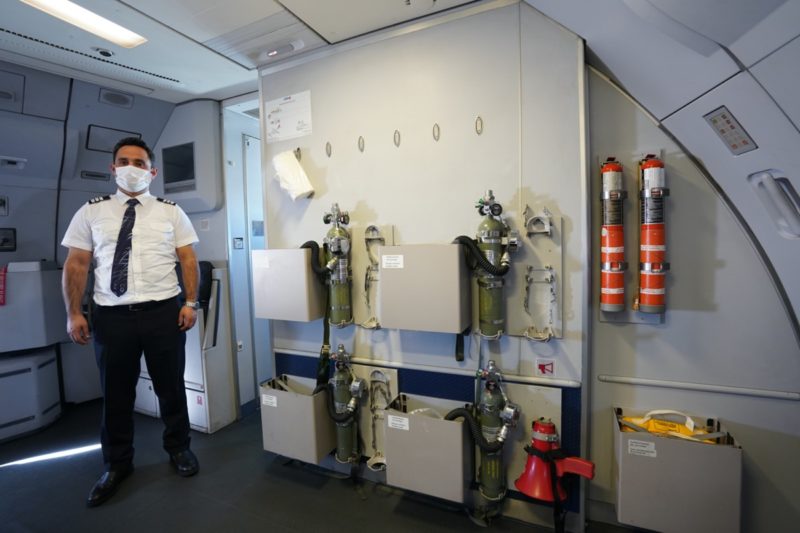 a man standing in a room with fire extinguishers