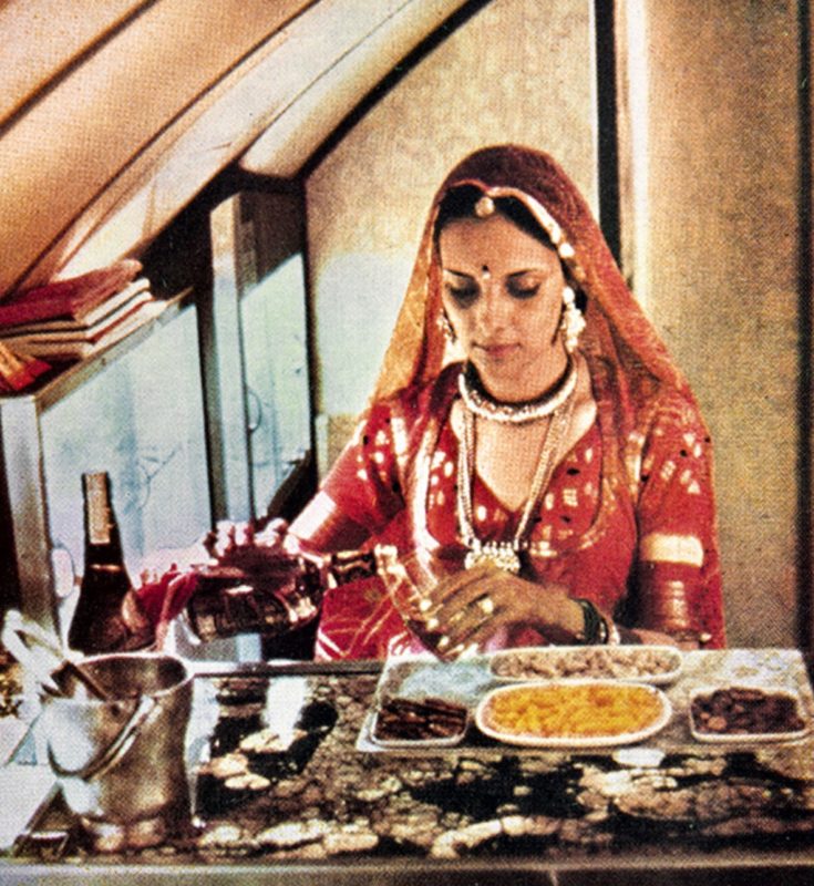 a woman in a red dress pouring food into a glass