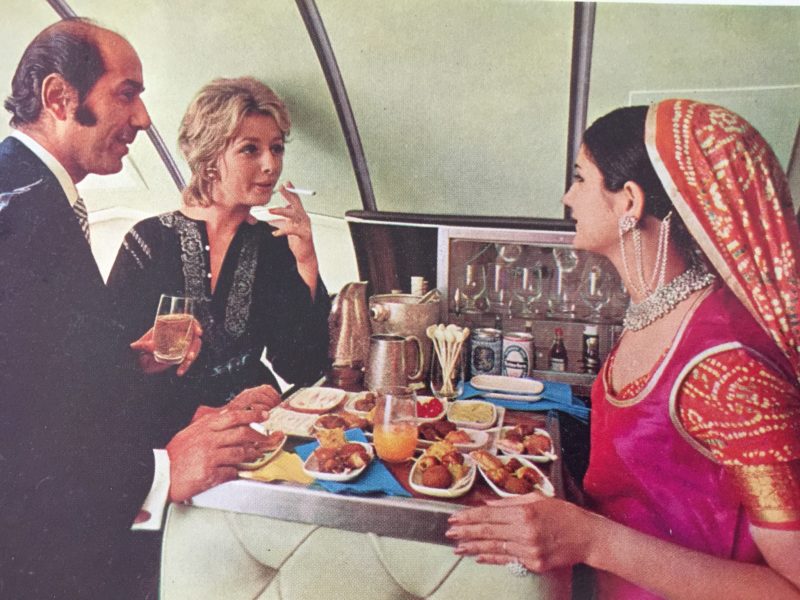 a group of people sitting around a table with food and drinks