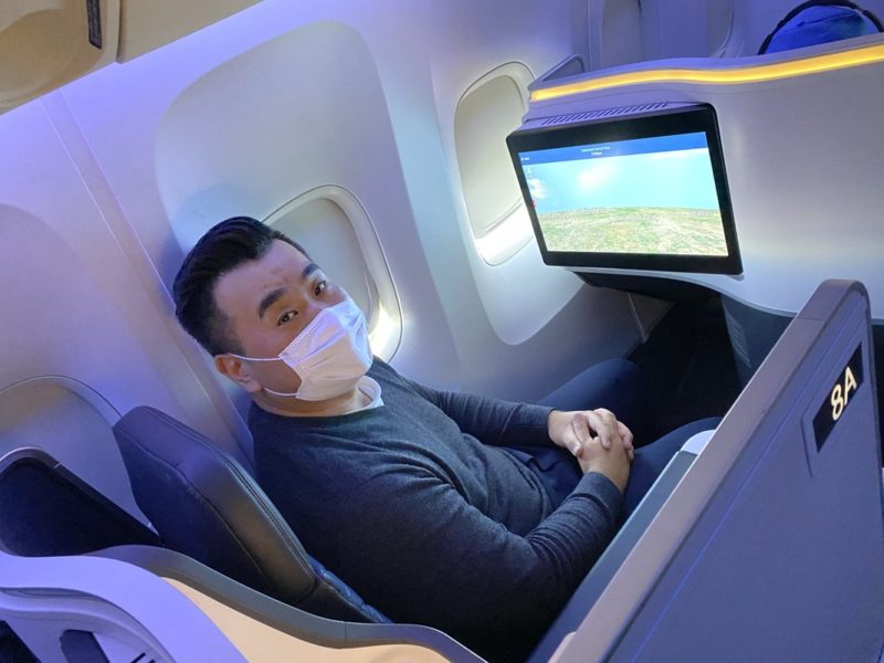 a man wearing a mask sitting in a plane