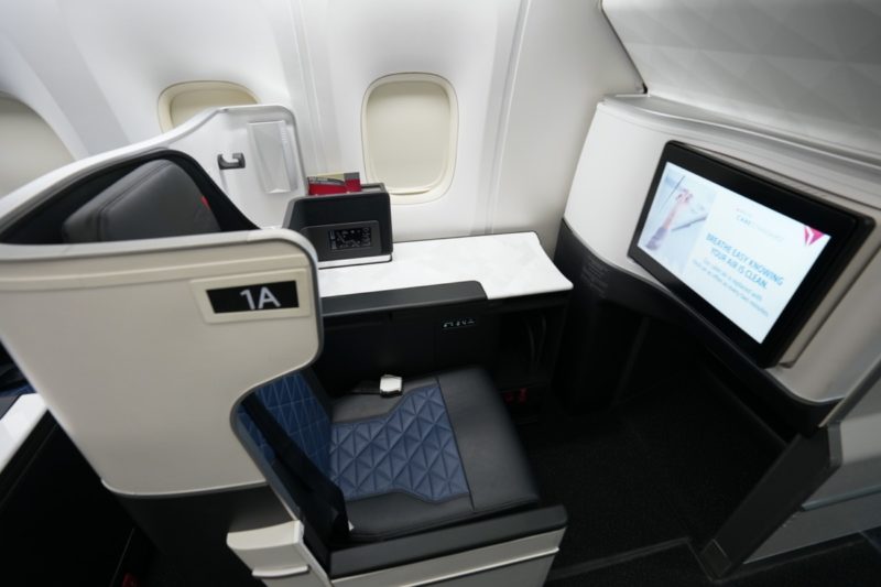a seat and a monitor in an airplane
