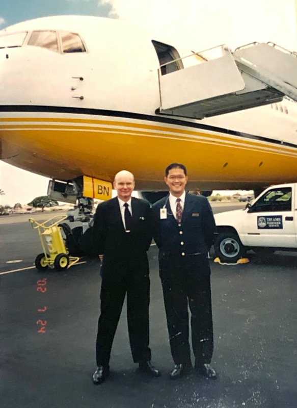 two men standing in front of an airplane