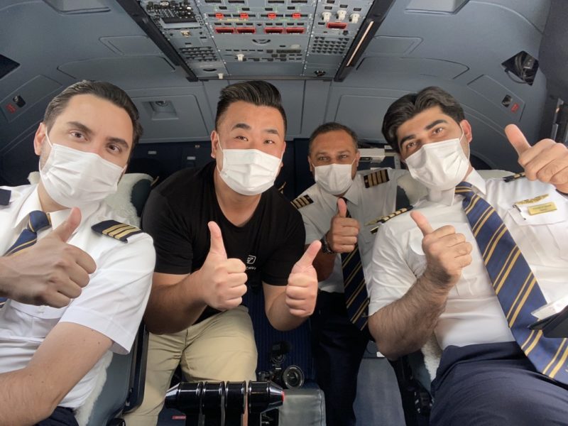 a group of men wearing face masks and giving thumbs up