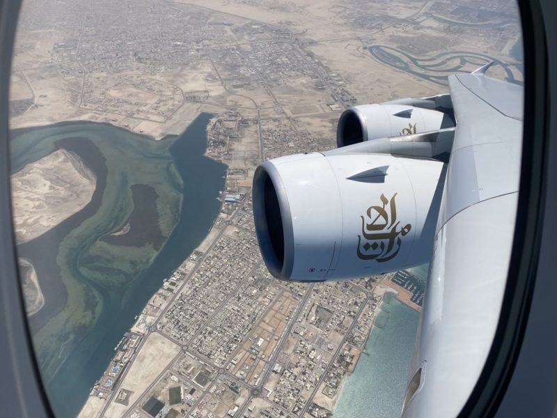 an airplane wing with a city and water in the background