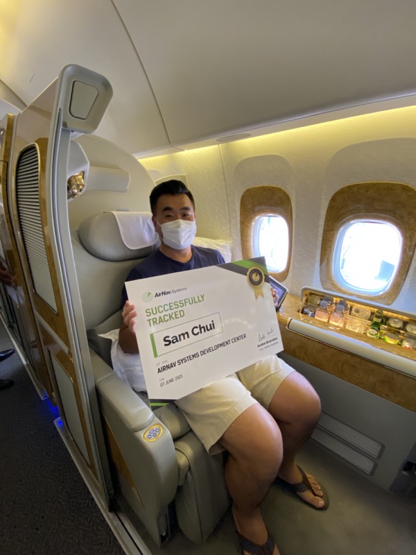 a man in a mask holding a certificate in an airplane