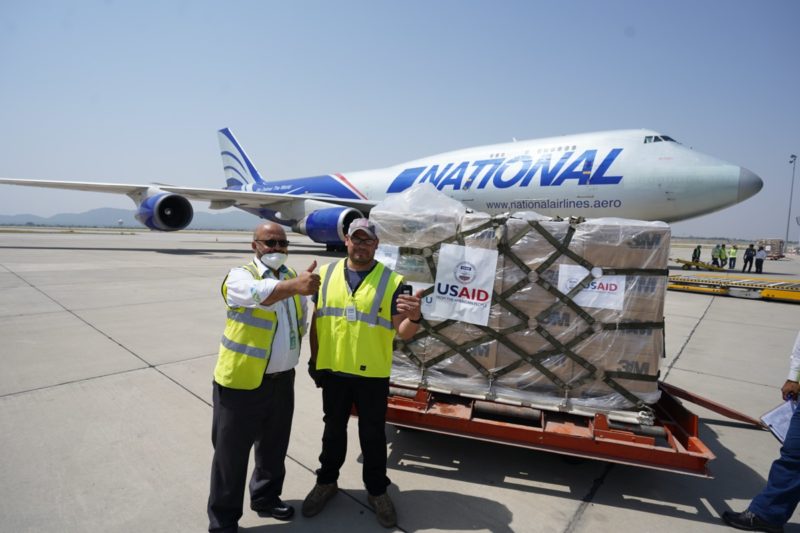 a couple of men standing next to a plane