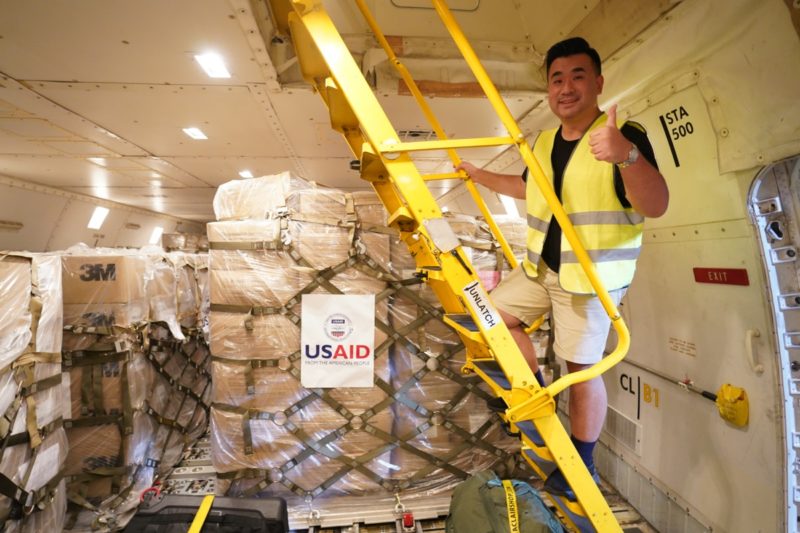 a man standing on a ladder in a cargo plane