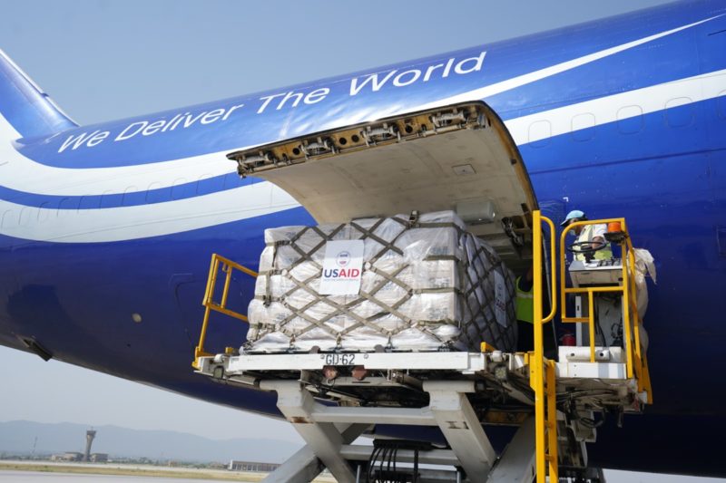 a plane loading cargo into a vehicle