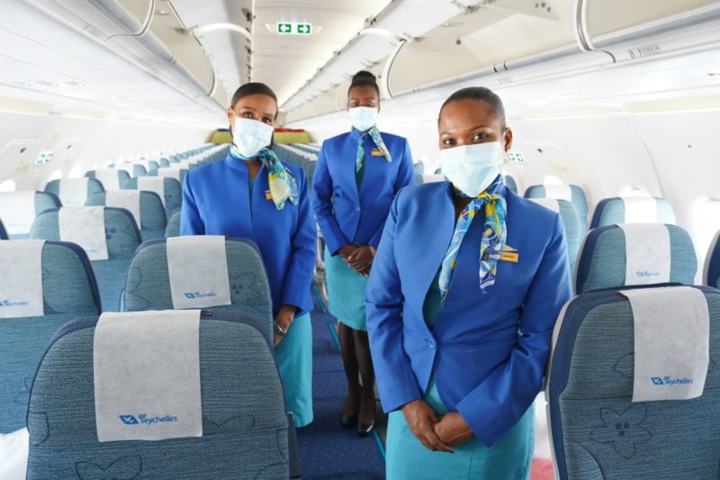 a group of women wearing blue uniforms and masks