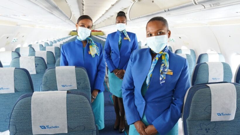 a group of women wearing blue uniforms and face masks