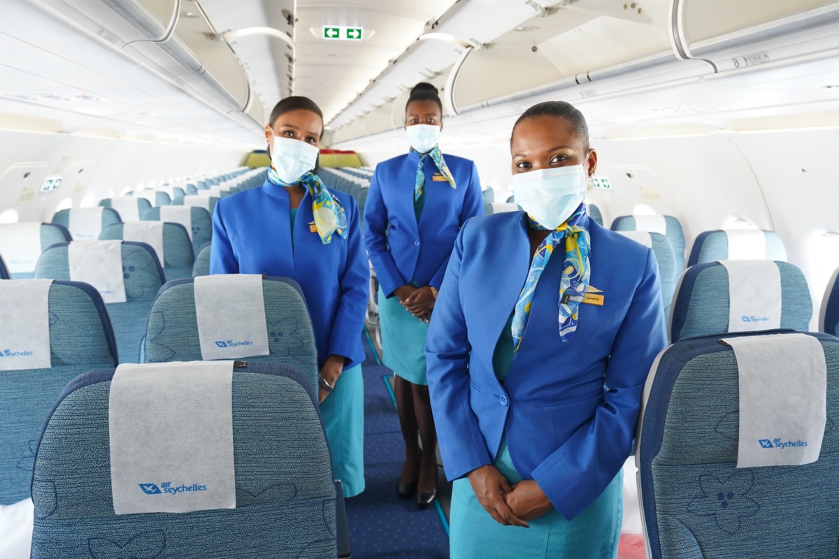 a group of women wearing blue uniforms and face masks