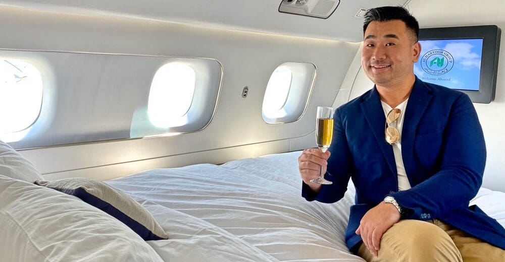 a man sitting on a bed holding a glass of champagne