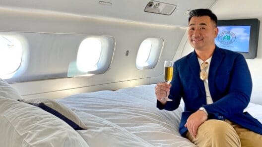a man sitting on a bed holding a glass of champagne