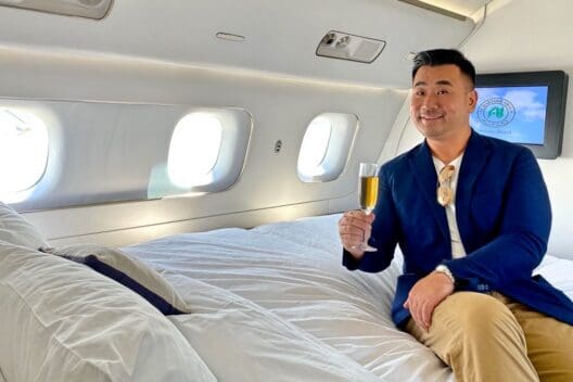 a man sitting on a bed holding a glass of champagne