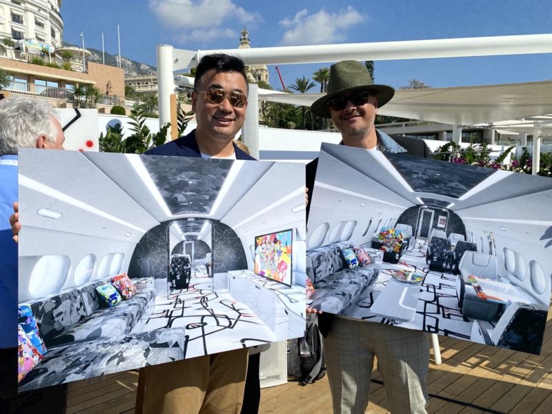 two men holding up posters of an airplane