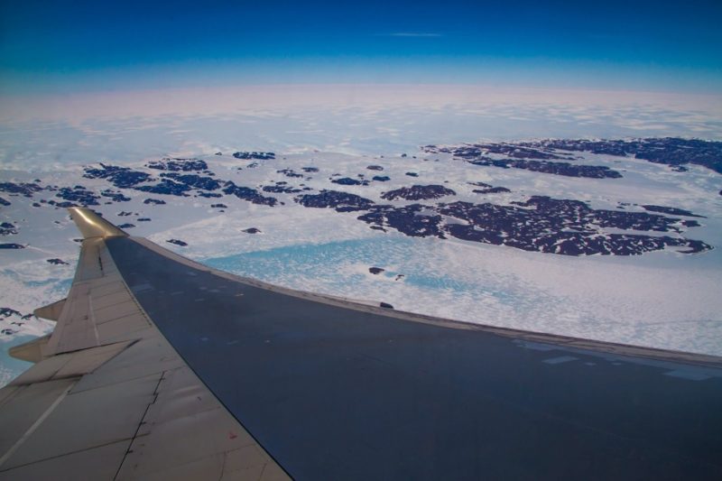 an airplane wing and an icy land