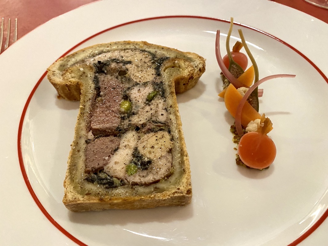 a piece of bread with meat and vegetables on a white plate
