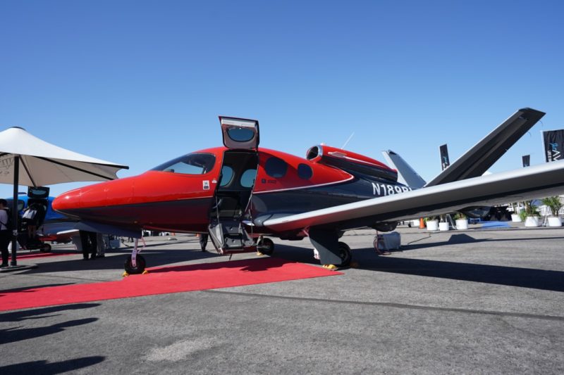 a red and black airplane with a door open