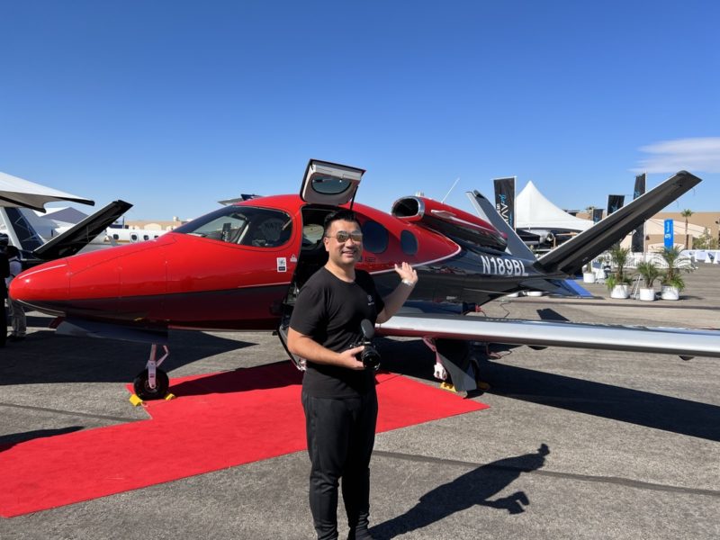 a man standing in front of a red and black airplane