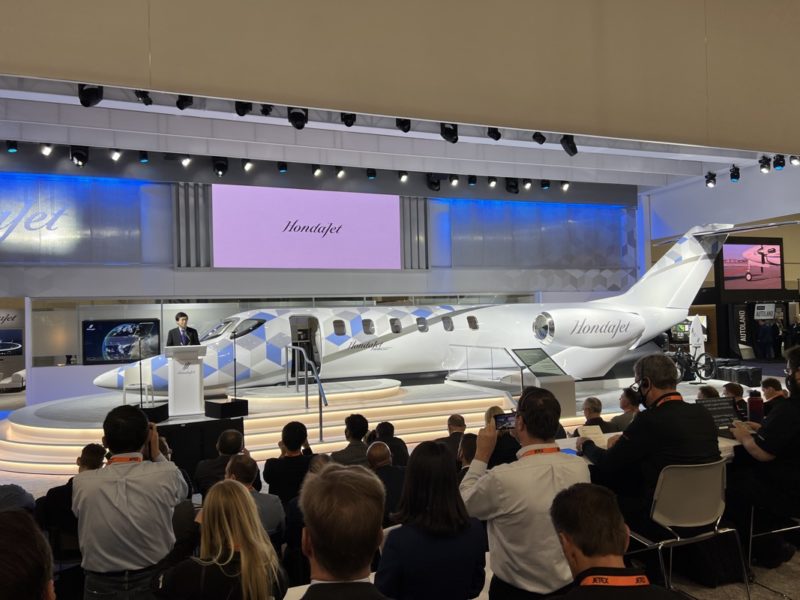 a group of people sitting in a room with a white airplane