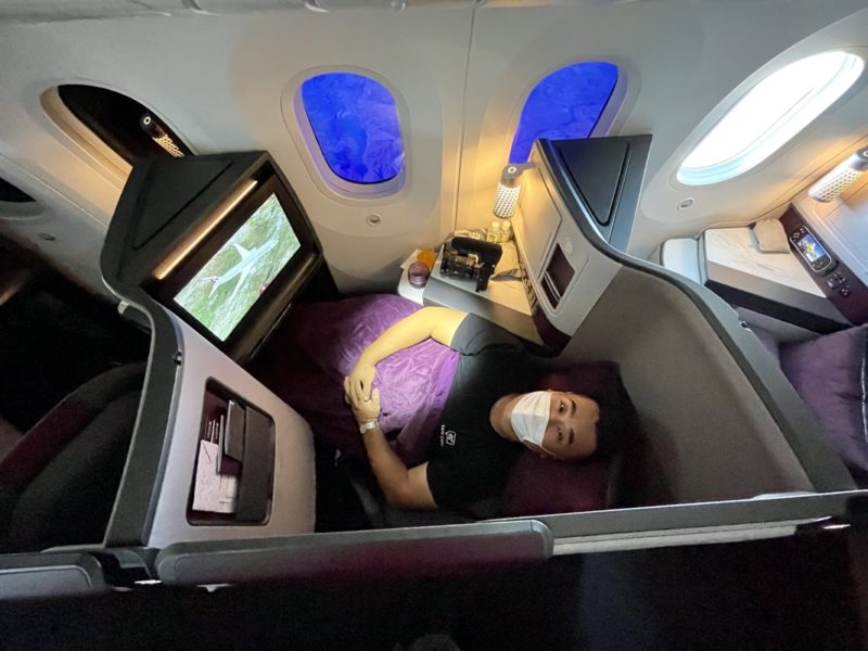 a man in a mask on a bed in an airplane