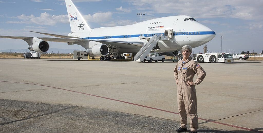 a woman standing in front of a plane