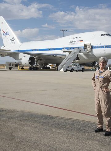 a woman standing in front of a plane