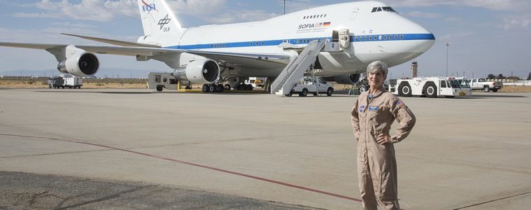 a woman standing in front of a plane