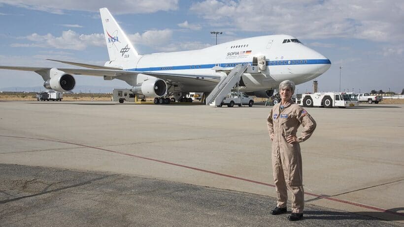 a woman standing in front of a plane