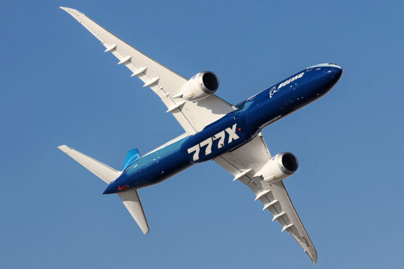 a blue and white airplane flying in the sky