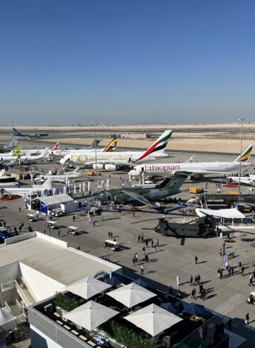 an airport with airplanes and people