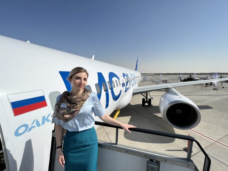 a woman standing on a railing next to a plane