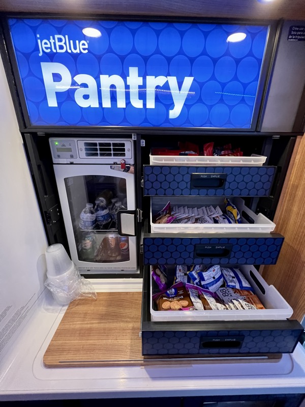 a pantry with a tv and a refrigerator