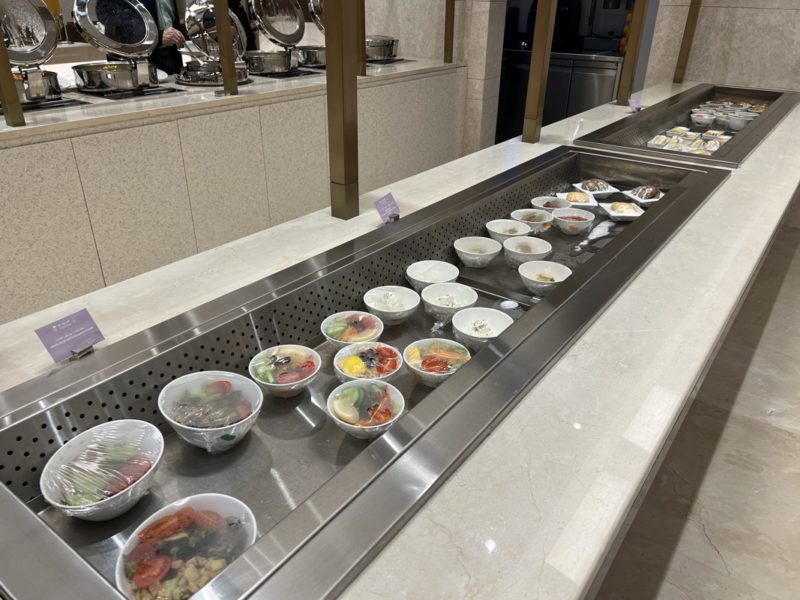 a row of bowls of food on a counter