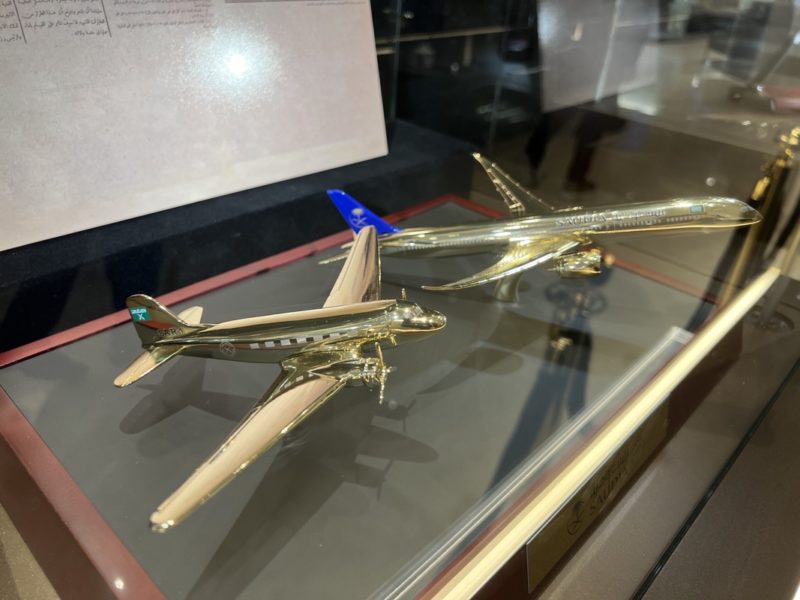 a gold model airplane on a glass case