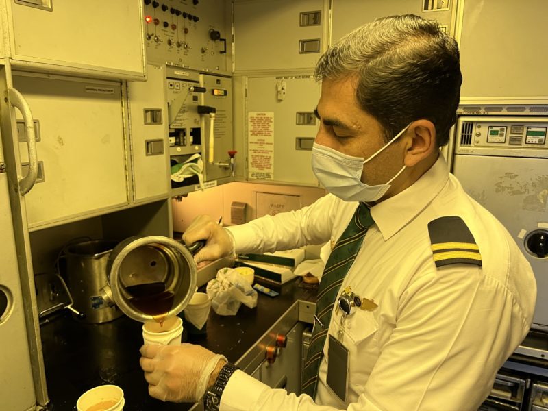 a man in uniform pouring coffee into a cup