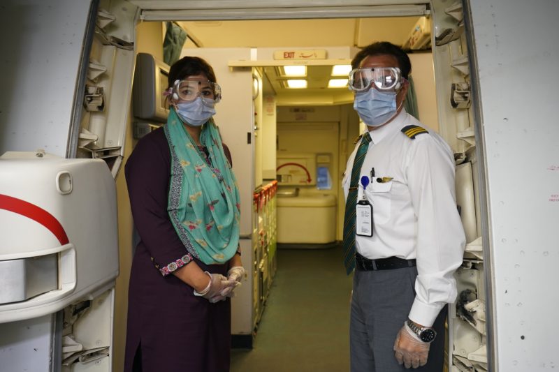 a man and woman wearing face masks and gloves