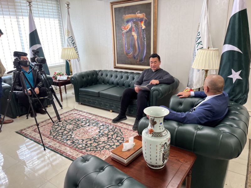 a man sitting on a couch in a room with a camera