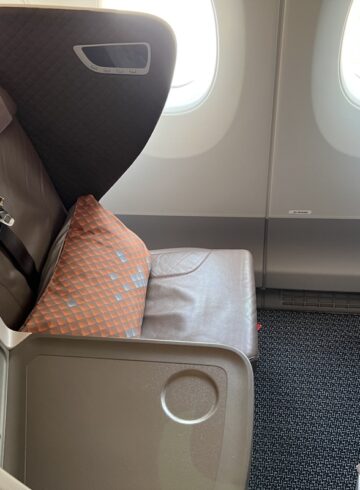 an airplane seat with a seat belt and a tv