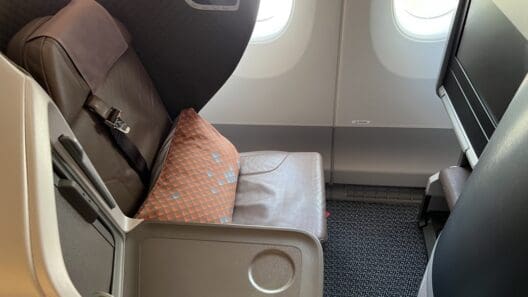 an airplane seat with a seat belt and a tv